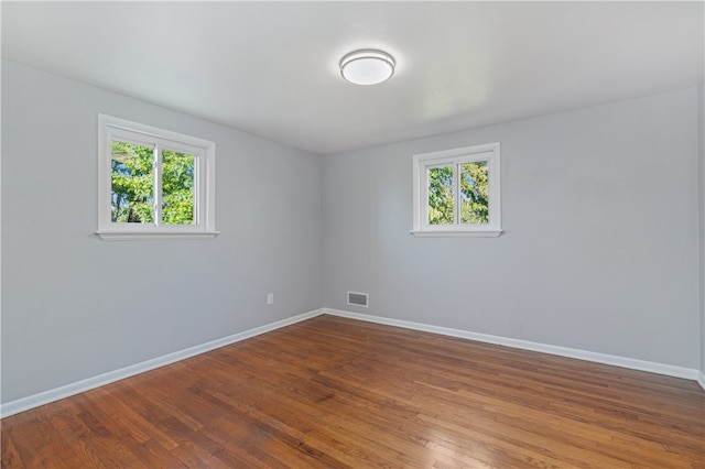 empty room with wood-type flooring and a healthy amount of sunlight