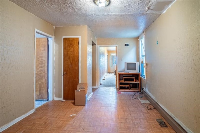 hall with light parquet flooring and a textured ceiling