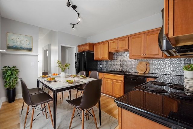 kitchen featuring black appliances, sink, light hardwood / wood-style floors, and tasteful backsplash