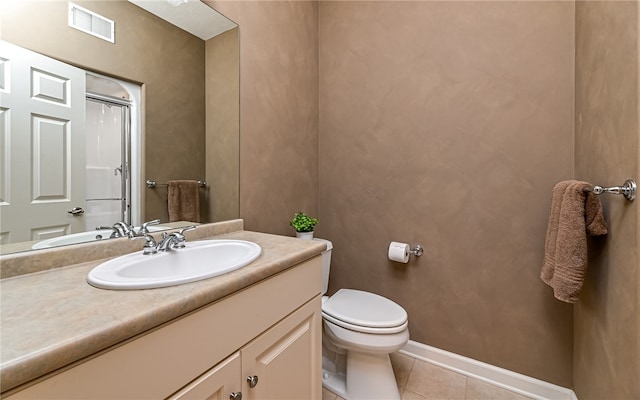 bathroom with vanity, tile patterned flooring, toilet, and a shower with door