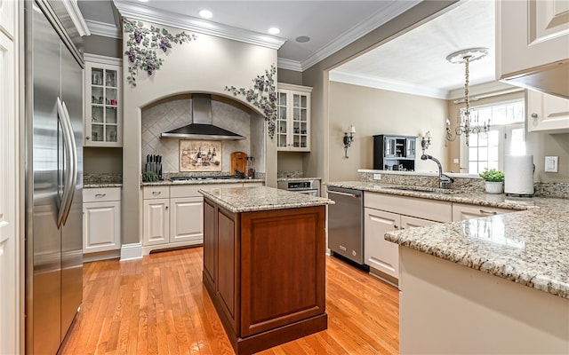 kitchen featuring hanging light fixtures, white cabinets, appliances with stainless steel finishes, and light hardwood / wood-style floors