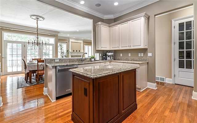 kitchen with dishwasher, light hardwood / wood-style flooring, hanging light fixtures, and kitchen peninsula