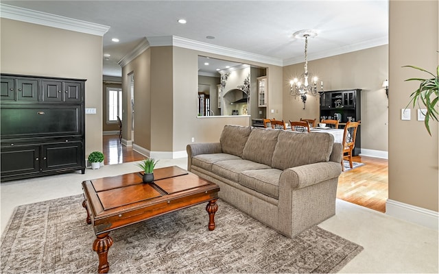 living room featuring light wood-type flooring, crown molding, and an inviting chandelier