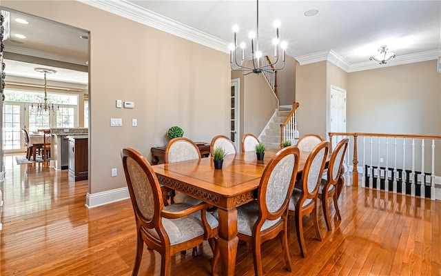 dining room with an inviting chandelier, light wood-type flooring, and crown molding