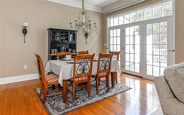 dining area featuring wood-type flooring and ornamental molding