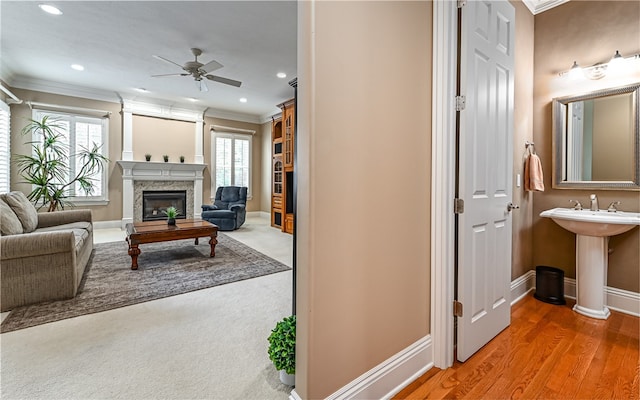 living room with ornamental molding, sink, ceiling fan, and hardwood / wood-style floors