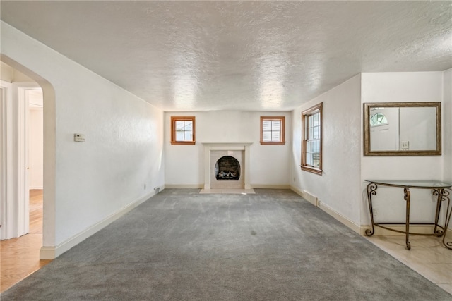 unfurnished living room with carpet and a textured ceiling