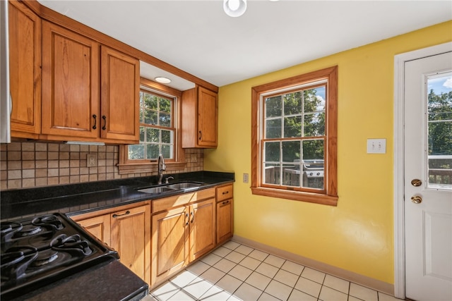 kitchen featuring decorative backsplash, light tile patterned floors, sink, and a wealth of natural light