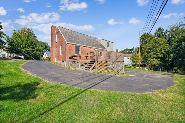 rear view of property with a yard and a deck