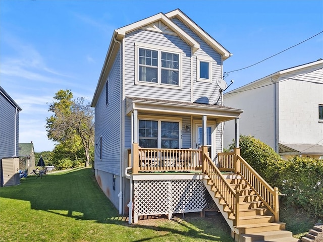 back of house with a lawn and covered porch