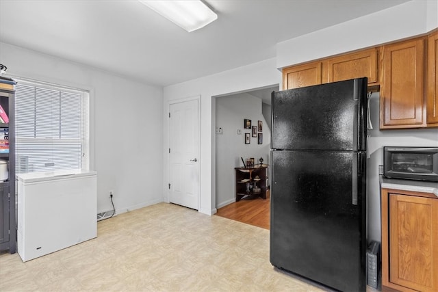 kitchen featuring light hardwood / wood-style flooring and black refrigerator