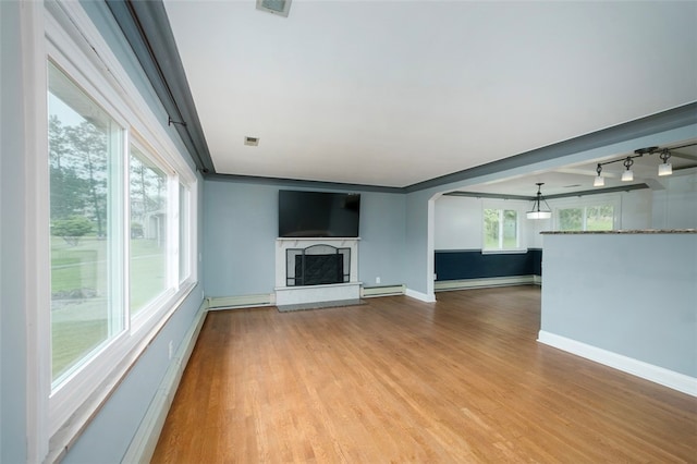 unfurnished living room featuring rail lighting, light hardwood / wood-style floors, and baseboard heating