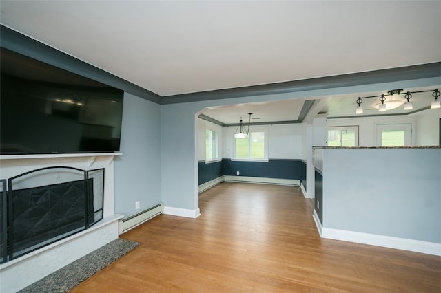 unfurnished living room with a premium fireplace, light wood-type flooring, and a baseboard radiator