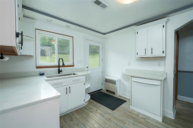 kitchen featuring radiator, white cabinetry, and sink