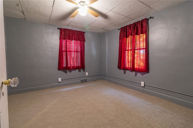 empty room with ceiling fan and a paneled ceiling