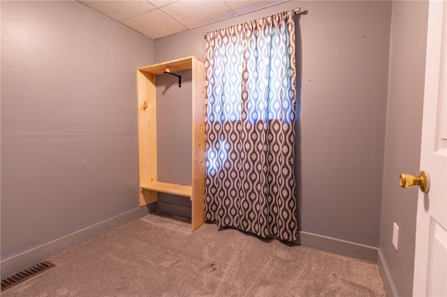 carpeted empty room featuring a paneled ceiling