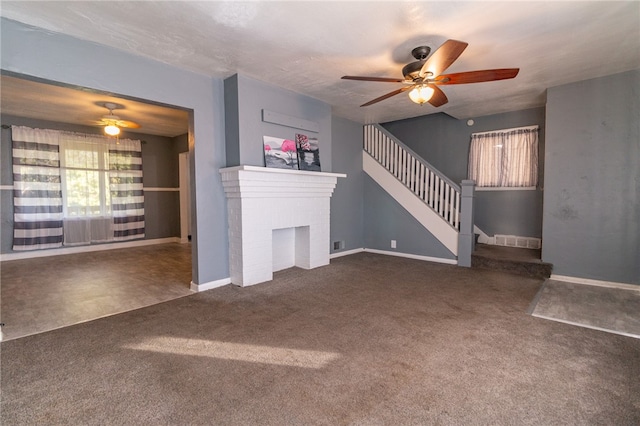 unfurnished living room featuring a brick fireplace, ceiling fan, and dark carpet