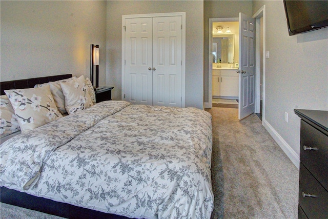 carpeted bedroom with a closet and ensuite bathroom