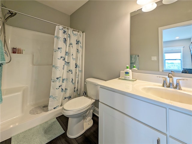 bathroom with toilet, vanity, walk in shower, and wood-type flooring