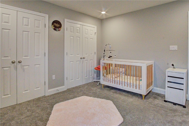 bedroom with a nursery area and carpet flooring