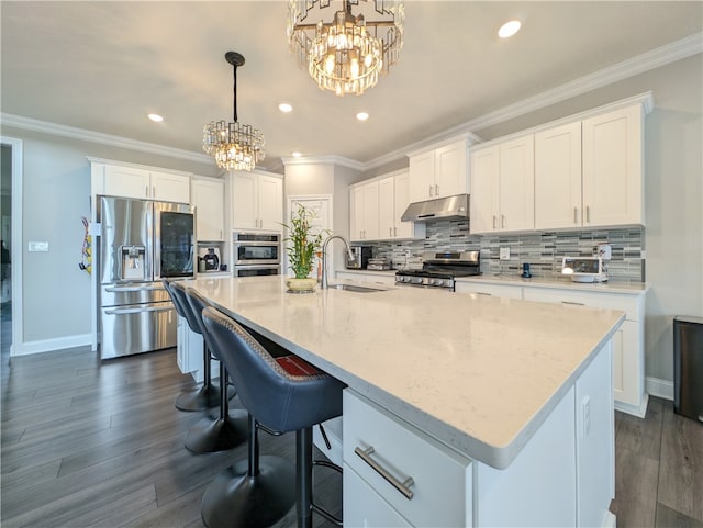 kitchen featuring stainless steel appliances, a kitchen island with sink, sink, and white cabinetry