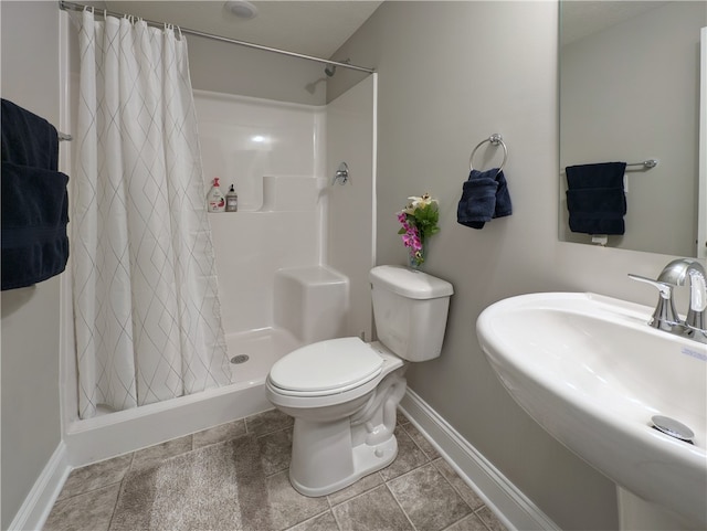 bathroom with walk in shower, sink, toilet, and tile patterned floors