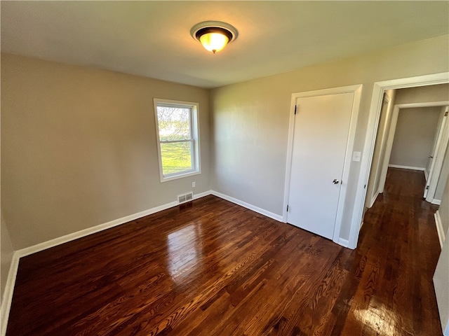 unfurnished bedroom featuring dark wood-type flooring