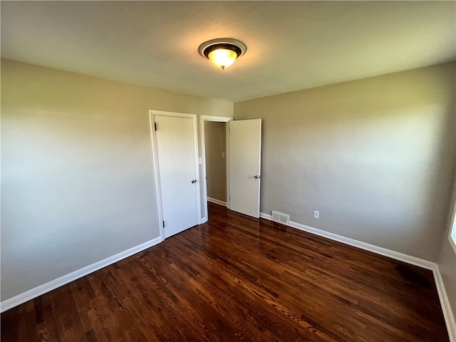 spare room with dark wood-type flooring