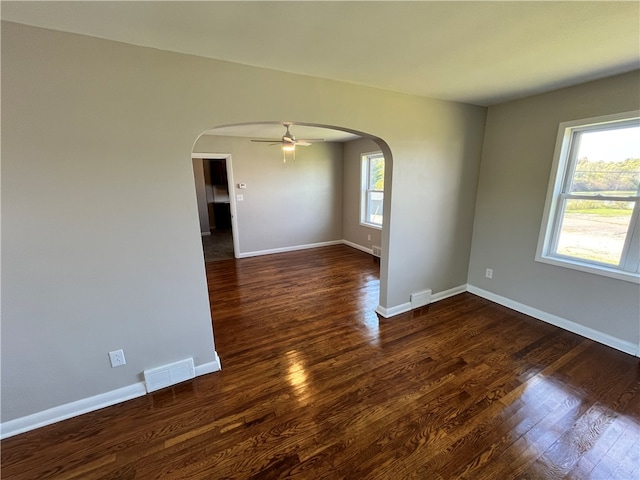 spare room with ceiling fan, dark hardwood / wood-style floors, and plenty of natural light