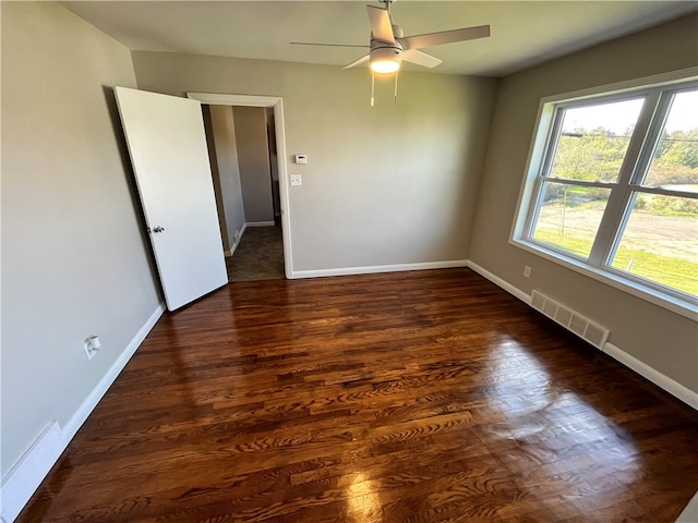 empty room featuring dark wood-type flooring and ceiling fan