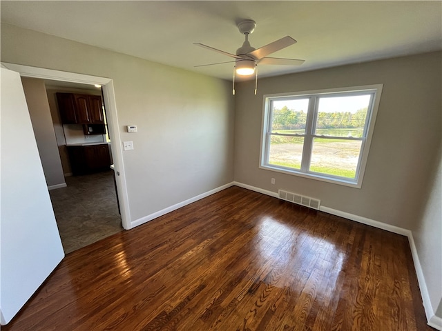 unfurnished room with ceiling fan and dark hardwood / wood-style flooring