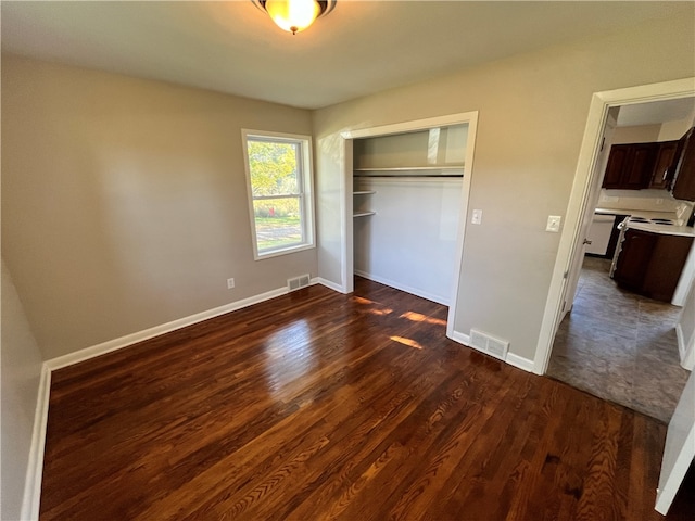 unfurnished bedroom featuring a closet and dark hardwood / wood-style flooring