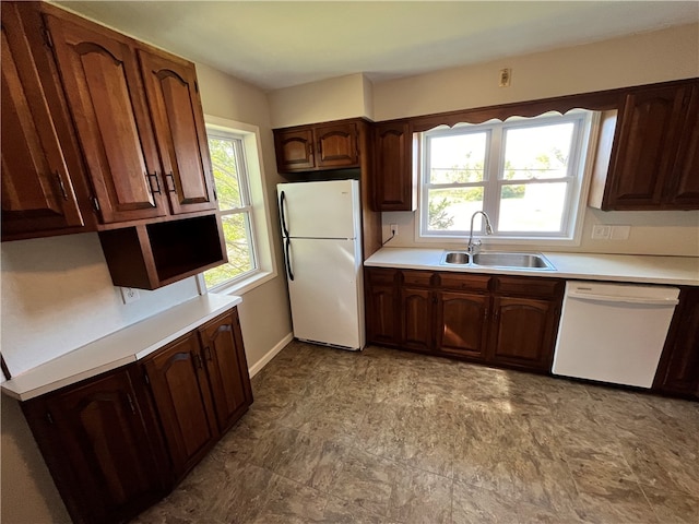 kitchen with sink, dark brown cabinetry, and white appliances