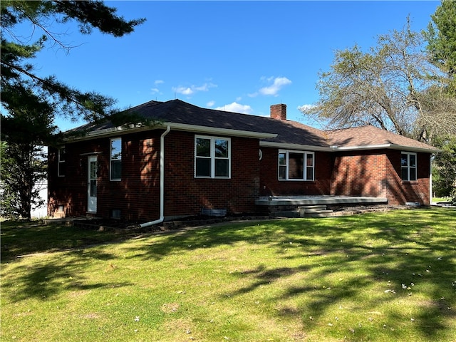 back of property featuring a lawn