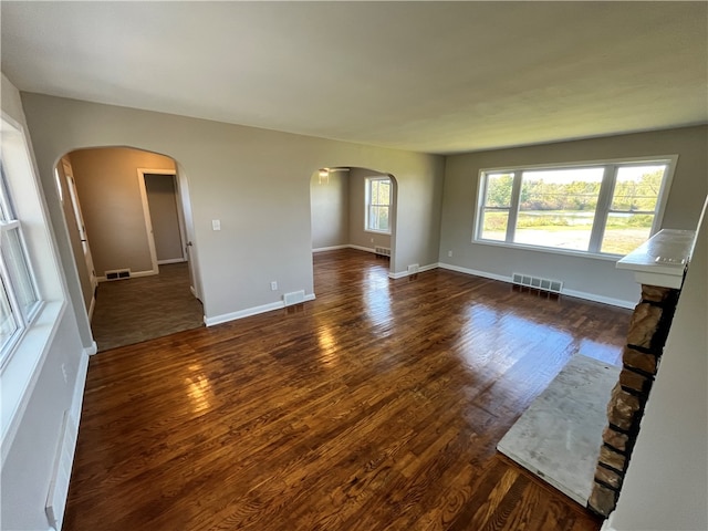 unfurnished living room featuring a fireplace and dark hardwood / wood-style flooring