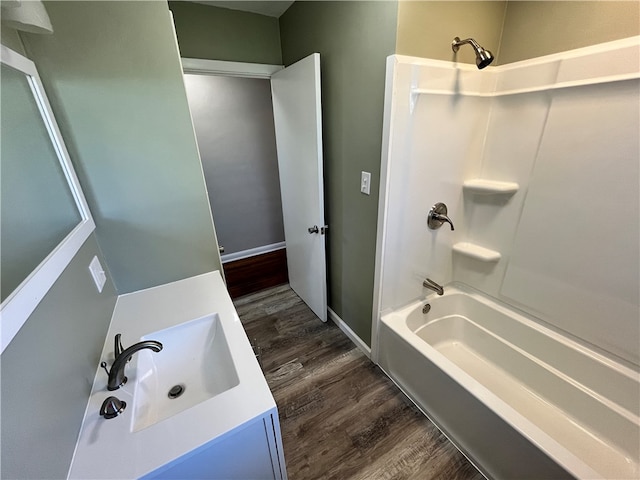 bathroom featuring vanity, washtub / shower combination, and wood-type flooring