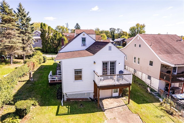 rear view of house featuring a wooden deck and a yard