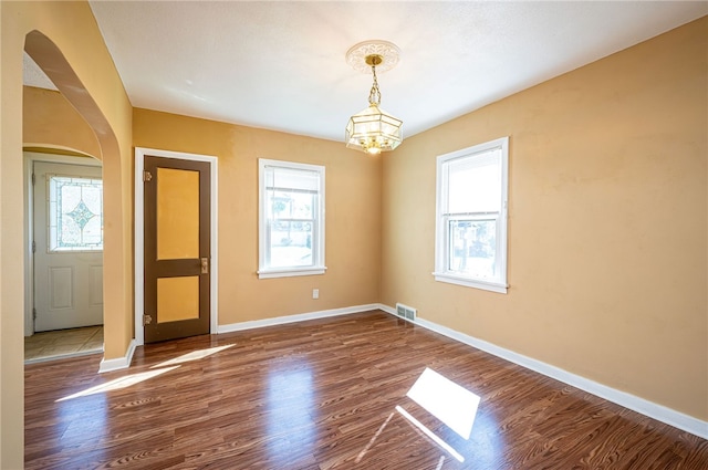 interior space featuring a notable chandelier, a healthy amount of sunlight, and hardwood / wood-style flooring