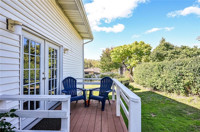 deck featuring french doors and a lawn