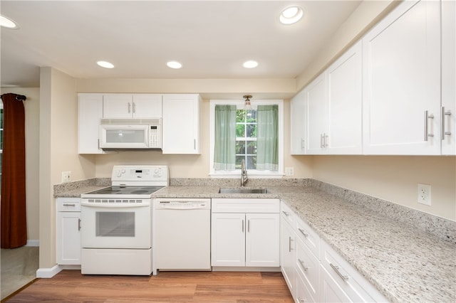 kitchen featuring white cabinets, white appliances, light hardwood / wood-style flooring, and sink