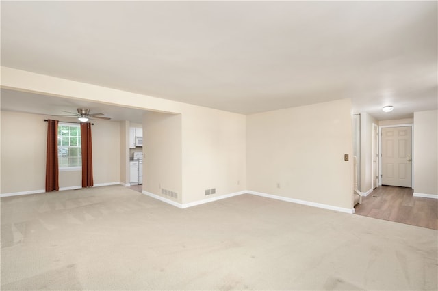 carpeted spare room with ceiling fan