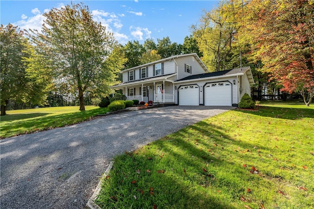 view of property with covered porch, a garage, and a front lawn