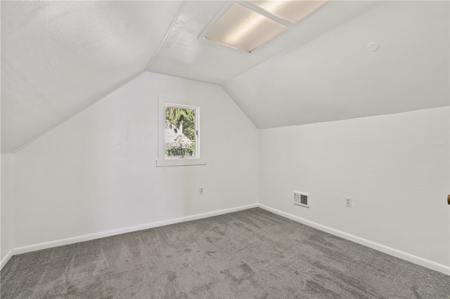 additional living space with vaulted ceiling and carpet flooring