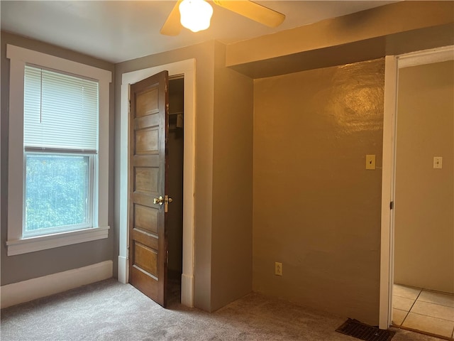 spare room with ceiling fan and light carpet