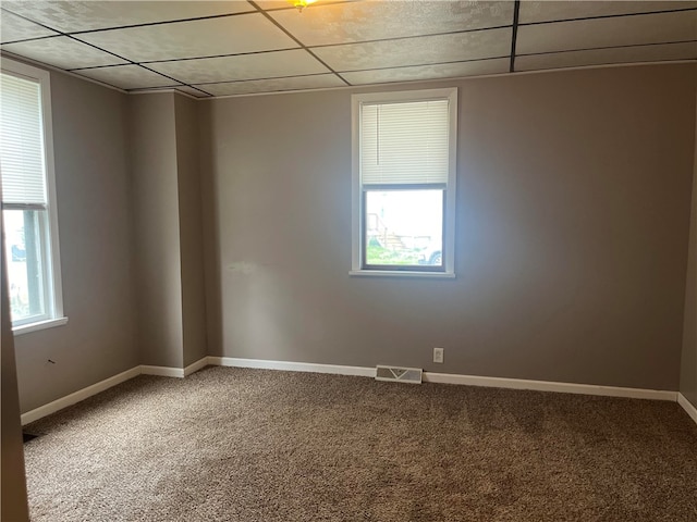 unfurnished room with plenty of natural light, a paneled ceiling, and carpet