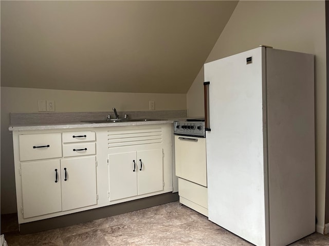 kitchen featuring white appliances, vaulted ceiling, sink, and white cabinetry