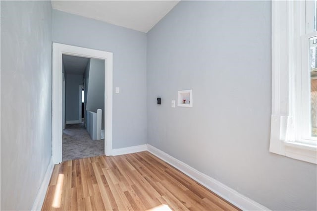 clothes washing area featuring washer hookup and light hardwood / wood-style flooring