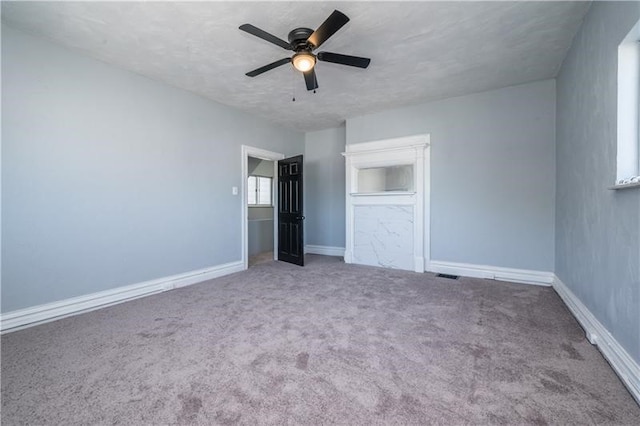 unfurnished bedroom with ceiling fan, carpet, and a textured ceiling