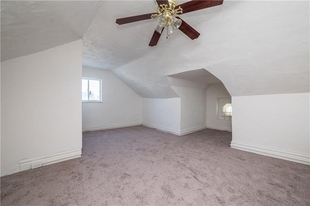 additional living space featuring lofted ceiling, light colored carpet, a textured ceiling, and ceiling fan