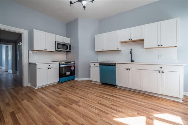 kitchen with white cabinets, appliances with stainless steel finishes, and sink